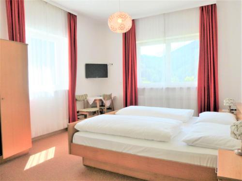 a bedroom with two beds and a large window at Garni B&B Apartments Plank in Nova Levante