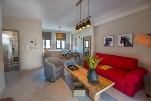een woonkamer met een rode bank en een tafel bij Marios Home, a cozy and spacious apartment near downtown in Preveza