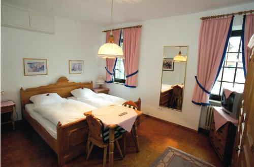 1 dormitorio con cama, mesa y TV en Gasthof Einhaus en Borken