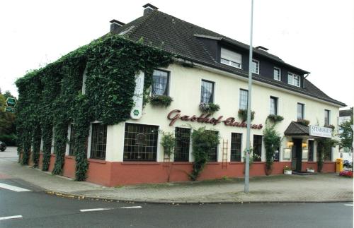 a building covered in ivy on the side of a street at Gasthof Einhaus in Borken
