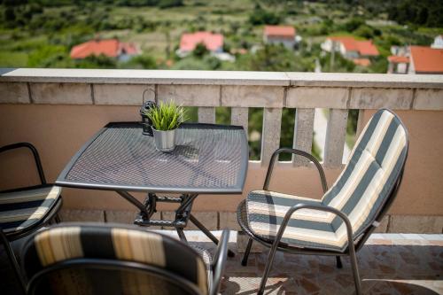 a table and chairs sitting on a balcony at Vila Marija in Rab