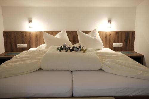 a large bed with white sheets and flowers on it at Apart Felsenhof in Längenfeld