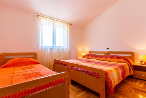 a bedroom with two beds and a window at Kuća za odmor - apartman Vito in Valtura