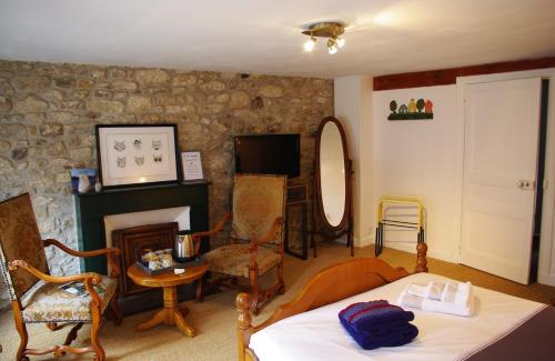 a living room with a bed and a fireplace at Ti Ar Bugale in Huelgoat