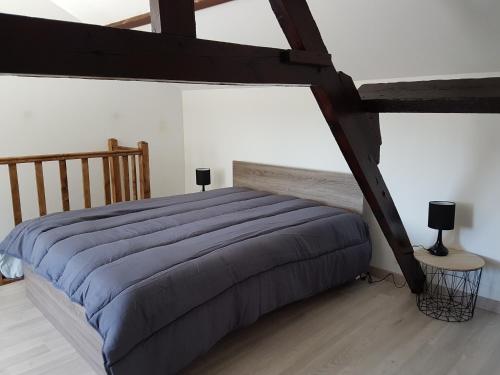 a bedroom with a bed with a blue comforter at La Cantraigne in Audembert