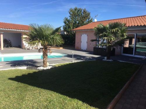 podwórze z basenem i dwoma palmami w obiekcie B&B Chez Florence - Chambres d'Hôtes w mieście Montmerle Sur Saône