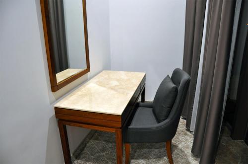 a desk with a chair and a mirror at Parliament Palace Hotel in Khujand