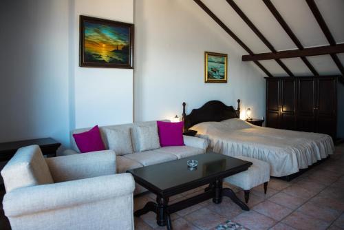 - un salon avec un canapé et un lit dans l'établissement Victoria Hotel Nessebar, à Nessebar