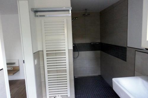 a shower with a white shutter in a bathroom at Messeappartement Unterrath in Düsseldorf