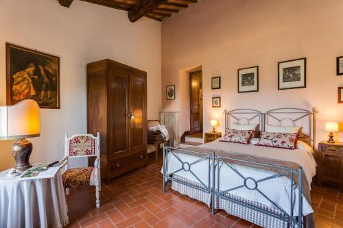 a bedroom with a bed and a table and a chair at Romitorio di Serelle in Barberino di Val dʼElsa