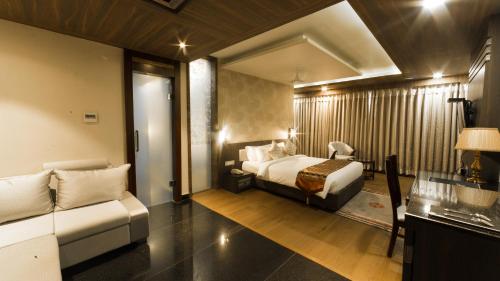 a hotel room with a bed and a couch at Costa Riviera Hotel in Varanasi
