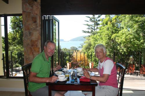 two older men sitting at a table with a drink at Double Dutch B & B in Knysna