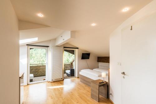 ein großes Wohnzimmer mit einem Bett und einem Fenster in der Unterkunft Hotel Obermayr in Ebenau
