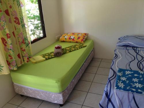 a small room with a bed and a window at Chez Taia et Véro in Tiputa