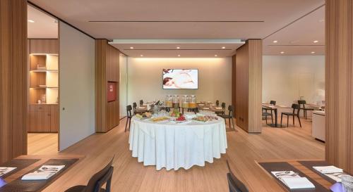 a dining room with a white table and chairs at Hotel Ocelle Thermae&Spa (Adults Only) in Sirmione