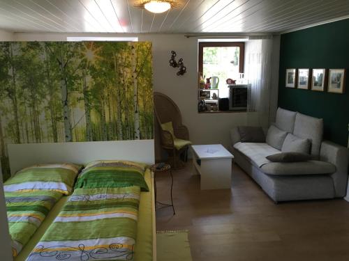 a living room with a bed and a couch at Anita's Zimmer in Engelhartszell