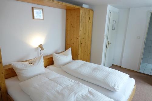 a bedroom with a bed with white sheets and pillows at Hofreit am Bierkeller in Kehl am Rhein