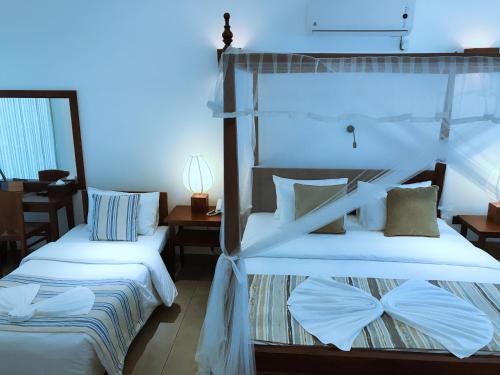 two beds in a room with blue lighting at Coza Ceylon in Mount Lavinia