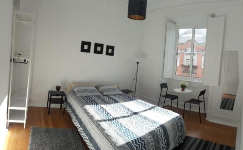 リスボンにあるFernando Pessoa Lisbon Roomsのベッドルーム1室(ベッド1台、テーブル、椅子付)