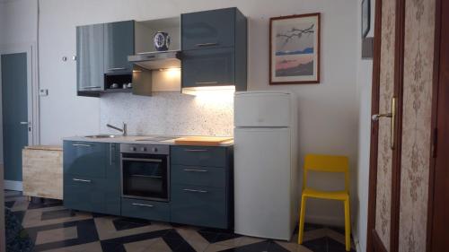 a kitchen with blue cabinets and a yellow chair at b&b Tosches in Barletta