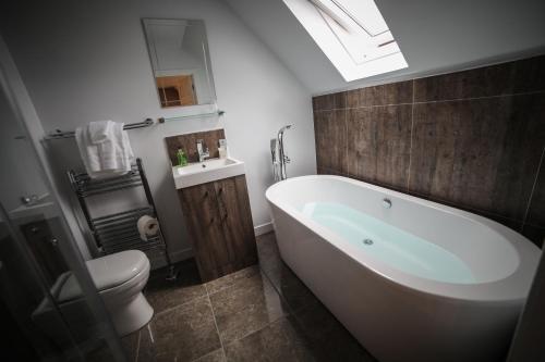 uma casa de banho com uma banheira branca e um WC. em Bay and Bridge em Dunfermline