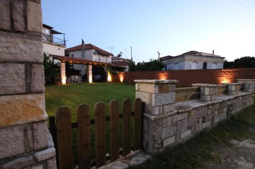 a stone retaining wall with a wooden fence at Chara host in Olympia