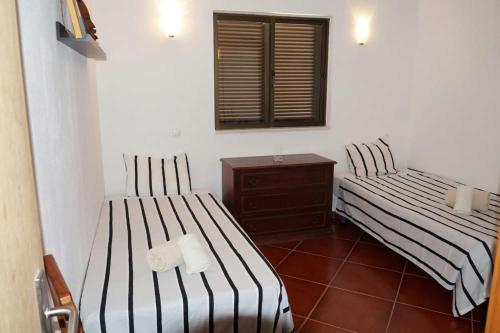 two beds in a room with a mirror at casa de ferias in Algoz