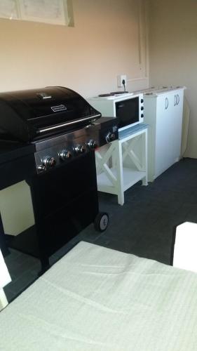 a room with a kitchen with a stove and a microwave at Sunflower Self-Catering in Walvis Bay