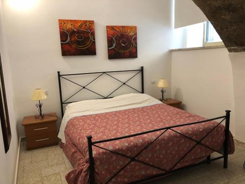 ein Schlafzimmer mit einem Bett und zwei Gemälden an der Wand in der Unterkunft Gli Archi in Montefiascone