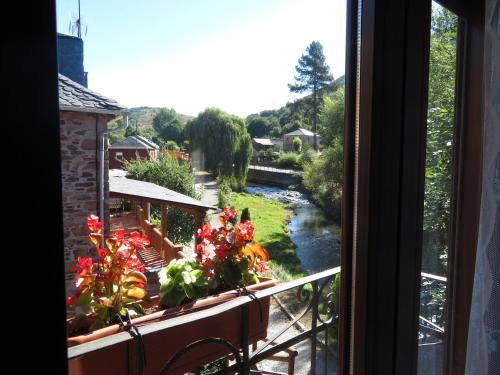 a window with a view of a river and flowers at Neverending Bierzo in Pobladura de las Regueras
