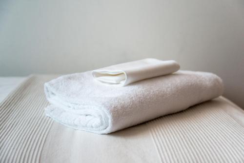 - une serviette blanche assise au-dessus du lit dans l'établissement Doge Veneziano, à Mestre