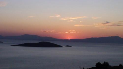 a sunset over a large body of water at Marmari View in Marmarion