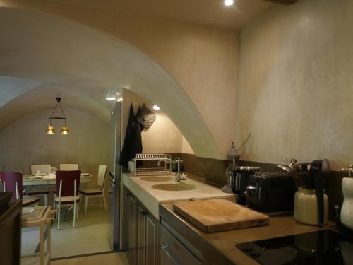 - une cuisine avec un évier et une voûte dans l'établissement La Calade, maison de village, à Gordes