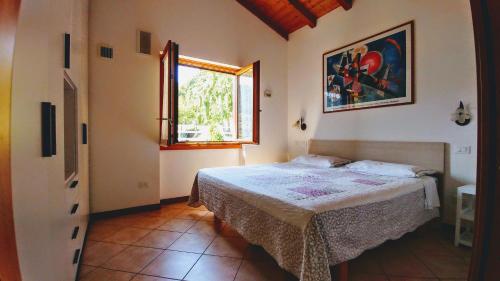 a bedroom with a bed and a window at The Balcony on the Lake in Dizzasco