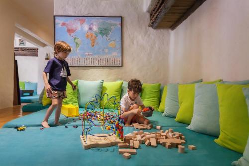 two young children playing with toys on a couch at Six Senses Zighy Bay in Dibba