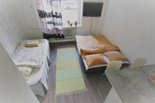 ユヴァスキュラにあるCity Centre Apartment Puistokatu 29のベッド2台とラグ付きの小さな部屋です。