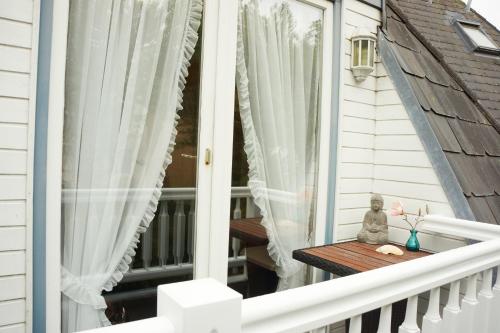a balcony with a table and a window at Hotel am Südwäldchen in Westerland (Sylt)