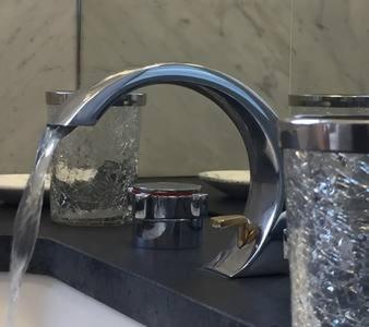 zlew w łazience z kranem wypływającym z wody w obiekcie Appartement Champs Elysées w Paryżu