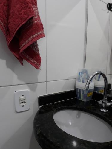 a bathroom with a sink and a red towel at Casa de amigos e parentes in Eunápolis