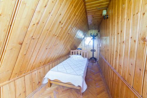 a small room with a bed in a wooden cabin at Eco House Sabero in Akhmety