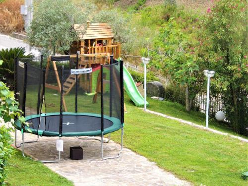 un parco giochi con tappeto elastico in un cortile di That's Amore Cilento Country House ad Agnone