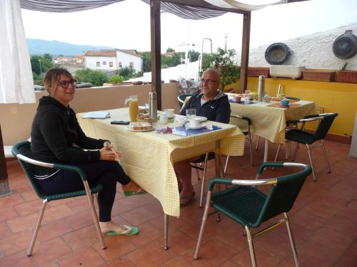 two people sitting at a table in a restaurant at B&B Tredomus in Tresnuraghes