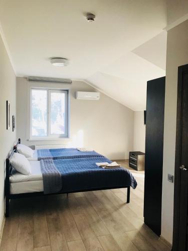 a bedroom with a bed with blue sheets and a window at Motozona in Briukhovychi