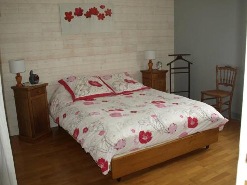 een bed in een slaapkamer met 2 nachtkastjes en 2 lampen bij La Risloise in Corneville-sur-Risle