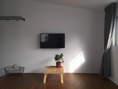 a living room with a table and a tv on a wall at 小時公館城西 in Yuli