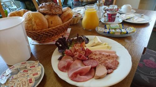een tafel met een bord eten en brood bij Gästehaus Café Heck Titisee in Titisee-Neustadt
