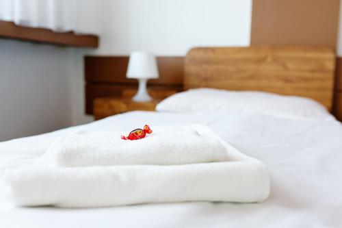 una rosa rossa seduta sopra due letti bianchi di Hotel Slovakia a Žilina