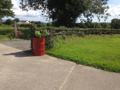 an orange barrel sitting on the side of a road at 'Uncle Owenie's Cottage' in Crossmaglen