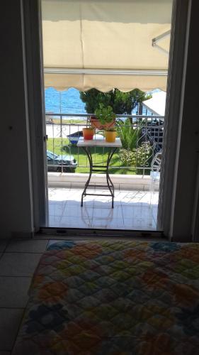 an open door to a patio with a table with pots on it at SeeTheSea Apartment Kanali in Preveza