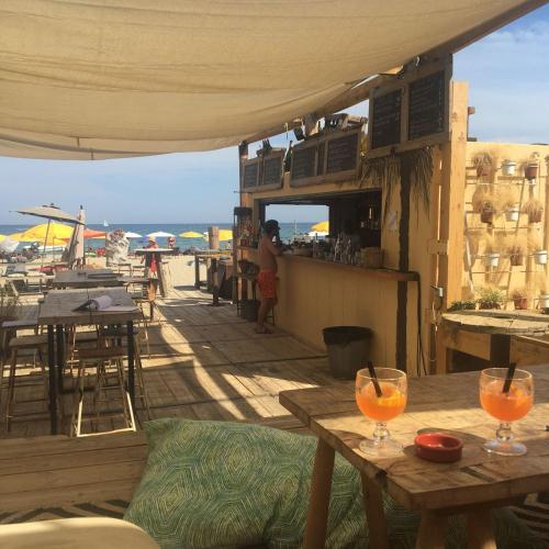 a patio with tables and a bar with a view of the ocean at Leucate in Leucate